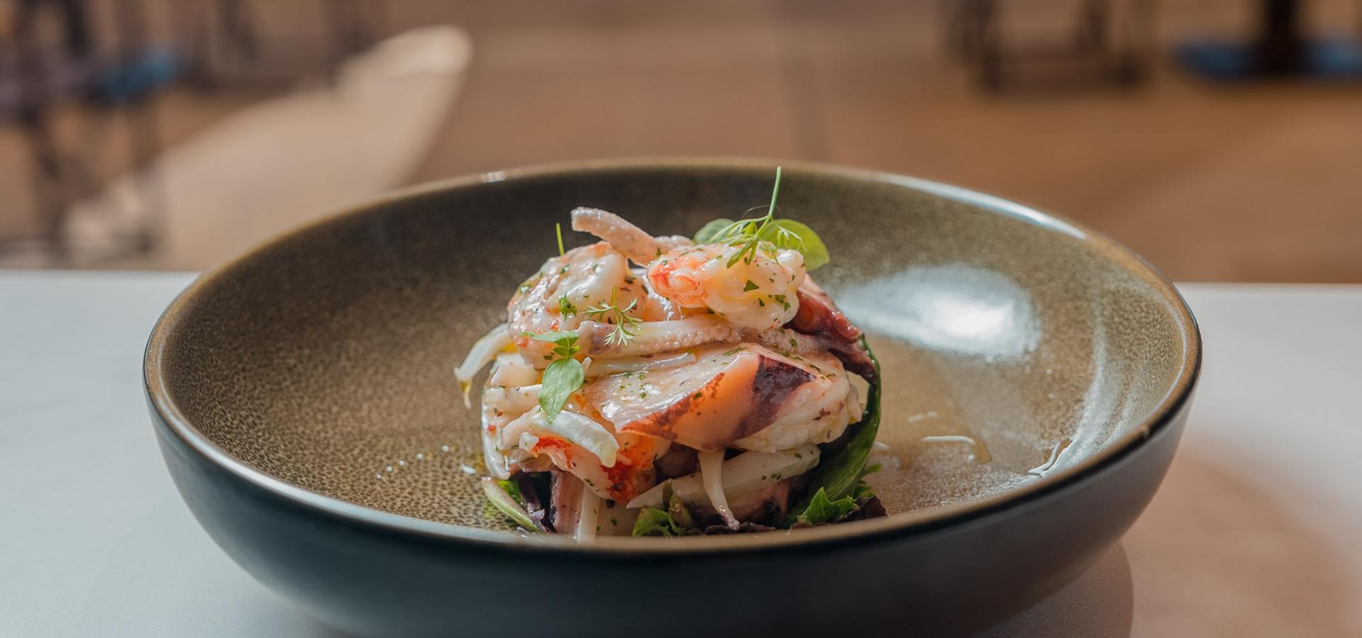 Insalata di mare con erbe fresche su piatto elegante.